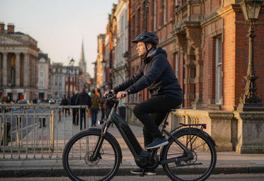 Commuter riding a HITWAY electric city bike through a UK city centre